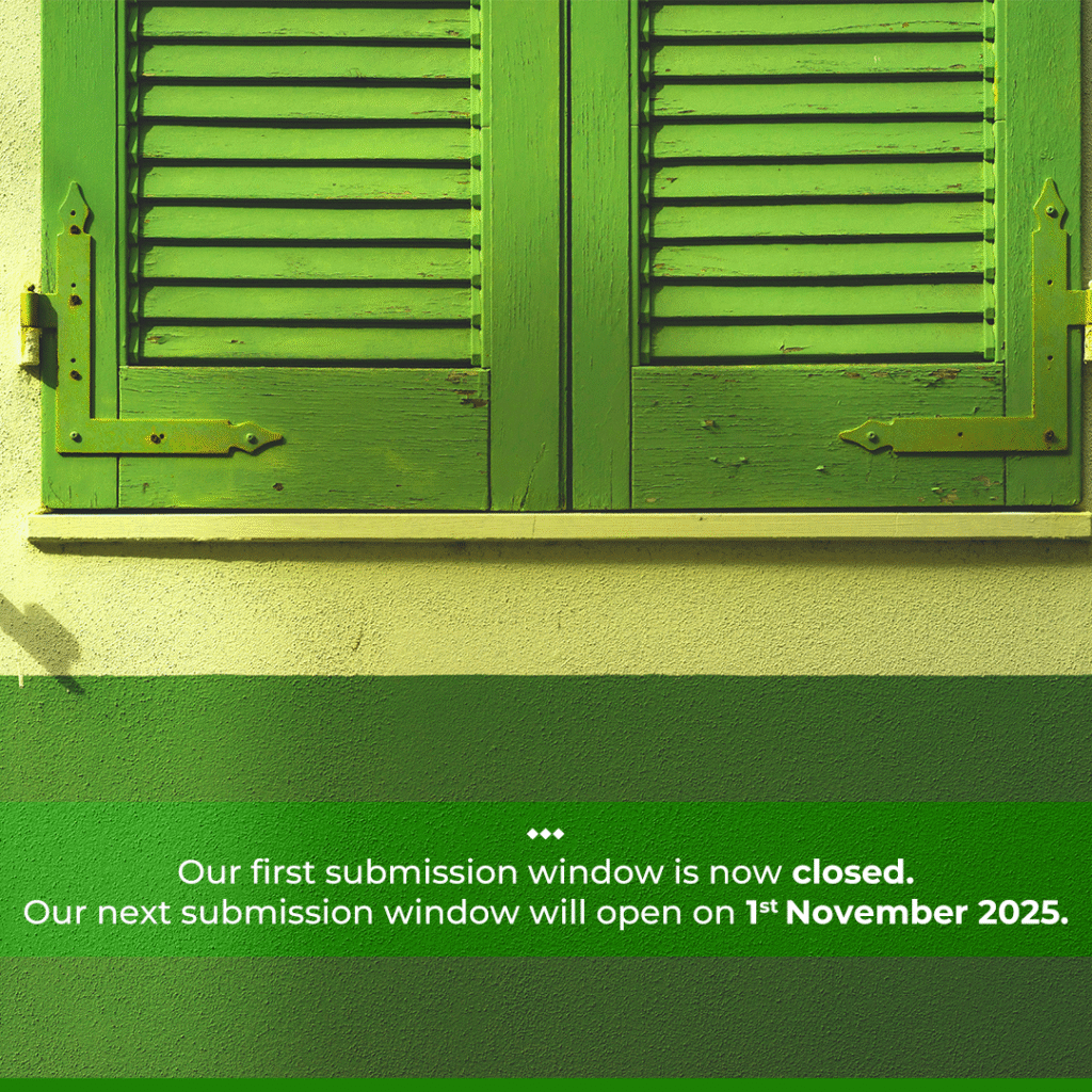 square, eye-level shot of a building exterior with a closed, bright green wooden shutter. The shutter is made of two panels with horizontal slats and is framed by a lighter green trim. Below the window is a wall painted in two shades of green, with a darker stripe at the bottom. Below the image, centered in white text, are three dots, followed by the text: "Our first submission window is now closed. Our next submission window will open on 1st November 2025."